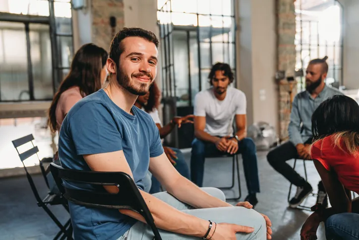 Portrait of a man looking at camera during a group therapy session